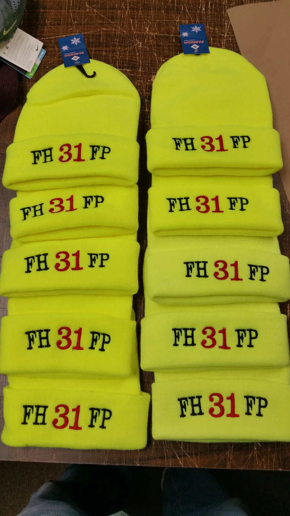 Hi-vis yellow beanies embroidered with a fire department FH 31 FP logo